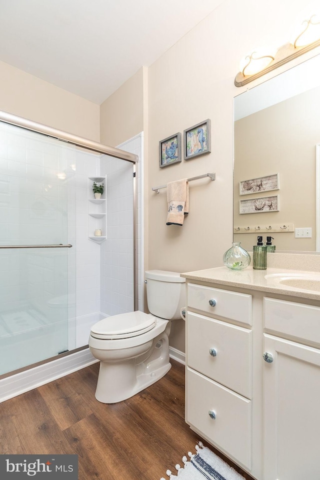 bathroom with vanity, hardwood / wood-style flooring, toilet, and walk in shower