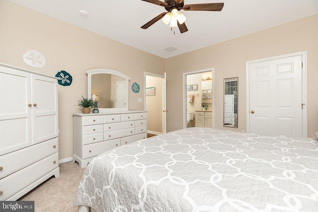 bedroom featuring ceiling fan, ensuite bathroom, and light carpet