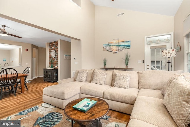 living room featuring ceiling fan, wood-type flooring, and high vaulted ceiling