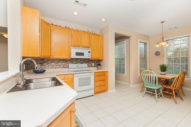 kitchen featuring decorative backsplash, white appliances, sink, pendant lighting, and a chandelier