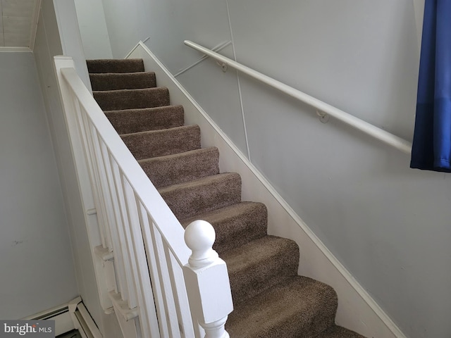 stairway featuring a baseboard heating unit