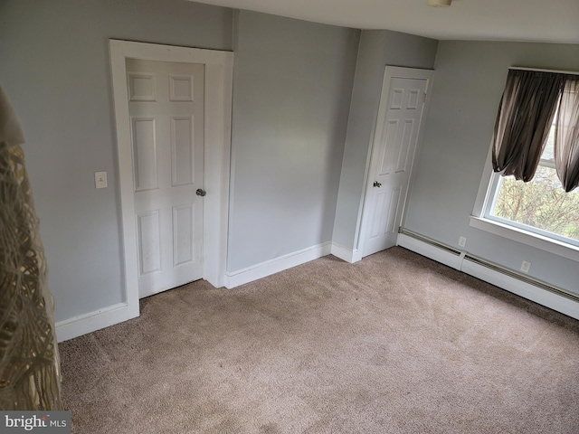 spare room featuring light colored carpet and a baseboard heating unit