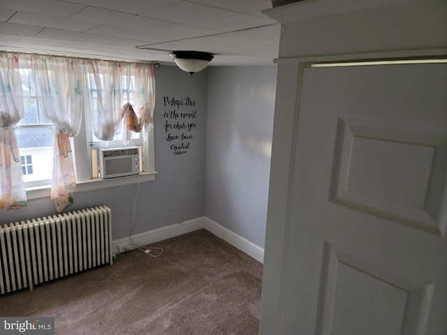 empty room with carpet floors, radiator, and cooling unit