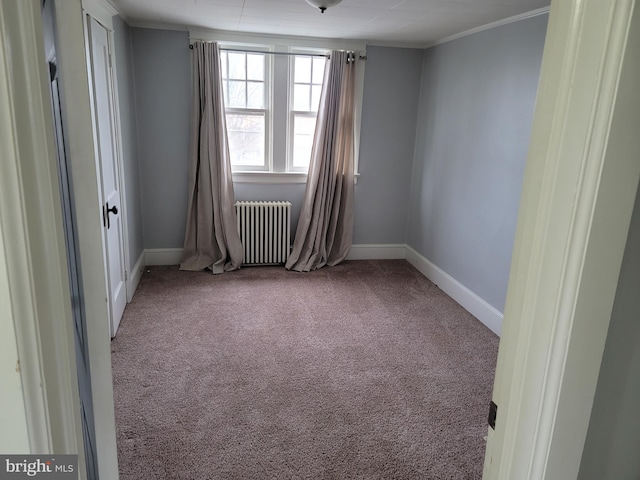 spare room featuring crown molding, radiator heating unit, and carpet floors