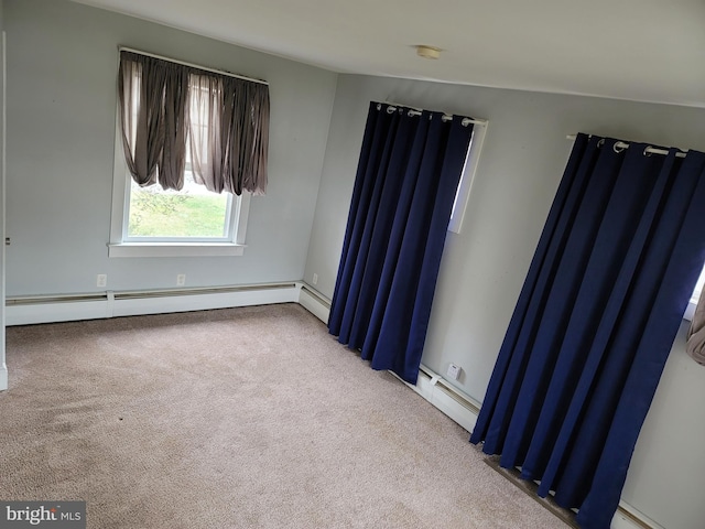 carpeted spare room featuring baseboard heating