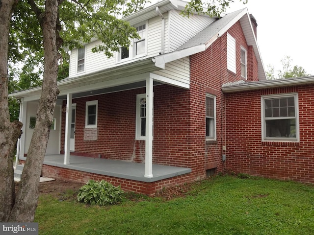 view of side of property featuring covered porch