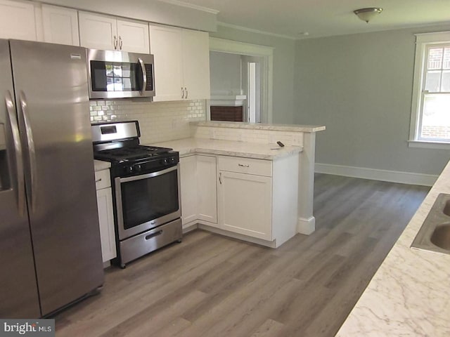 kitchen with kitchen peninsula, dark hardwood / wood-style flooring, stainless steel appliances, and white cabinetry