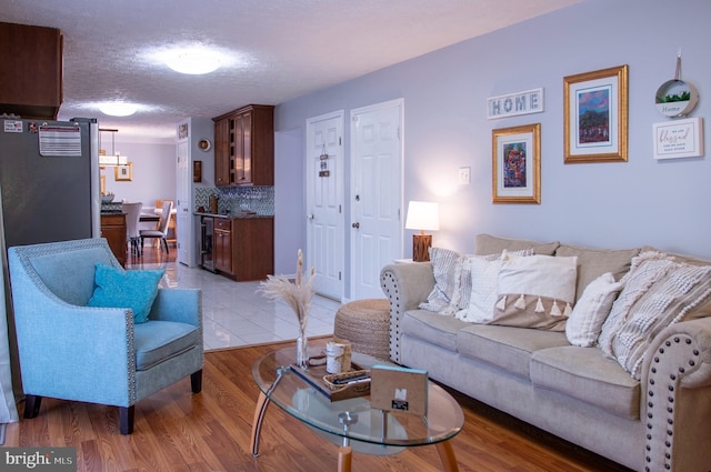 living room featuring a textured ceiling, hardwood / wood-style flooring, and beverage cooler