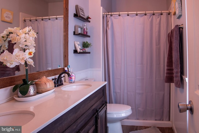 bathroom with vanity, a shower with shower curtain, and toilet