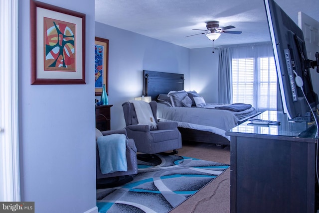 carpeted bedroom with ceiling fan and a textured ceiling