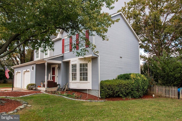 view of property with a garage and a front yard