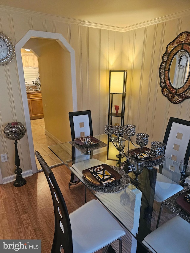 dining space featuring hardwood / wood-style floors and ornamental molding