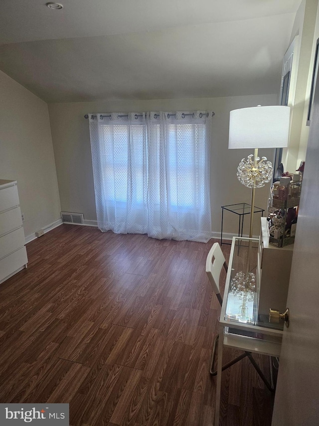 dining area with dark hardwood / wood-style flooring and a chandelier