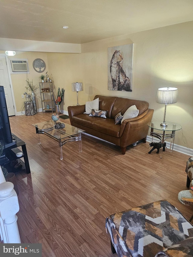 living room with wood-type flooring and an AC wall unit