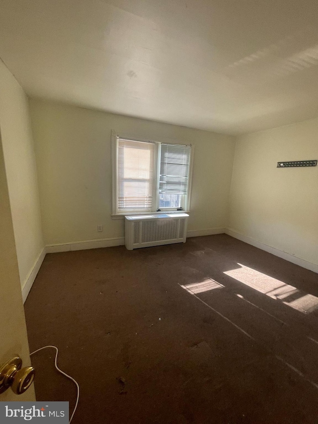 carpeted spare room with radiator