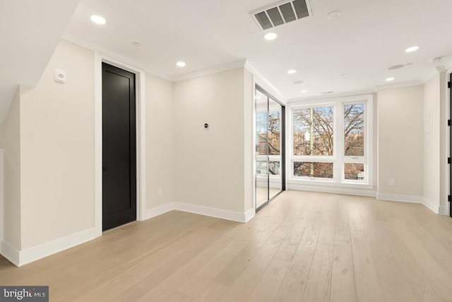 interior space with crown molding and light hardwood / wood-style flooring