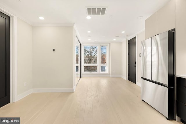 interior space with light hardwood / wood-style floors and ornamental molding