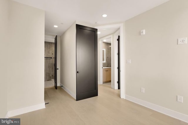 interior space featuring light wood-type flooring and connected bathroom