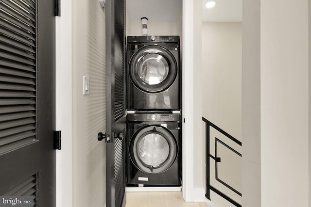 clothes washing area with stacked washer / dryer and light tile patterned floors