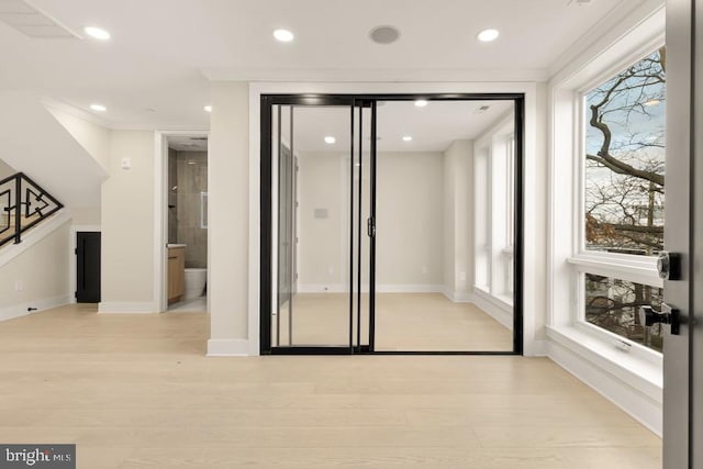 empty room featuring crown molding and light hardwood / wood-style floors