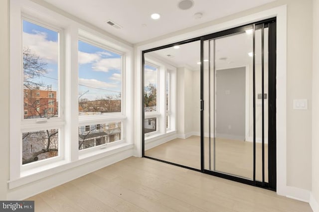 doorway featuring plenty of natural light and light hardwood / wood-style flooring