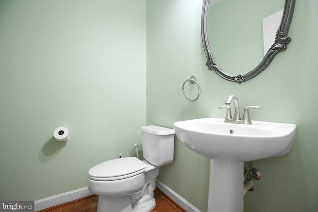 bathroom featuring hardwood / wood-style flooring and toilet