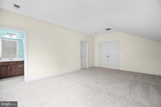 interior space with light colored carpet and lofted ceiling