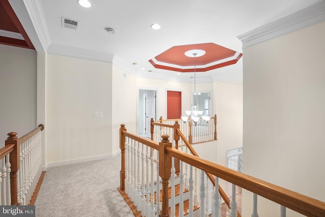 hall featuring a chandelier, carpet floors, and ornamental molding