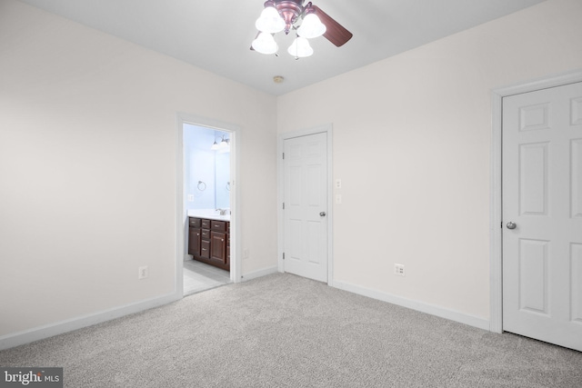 unfurnished bedroom featuring ensuite bathroom, ceiling fan, and light carpet