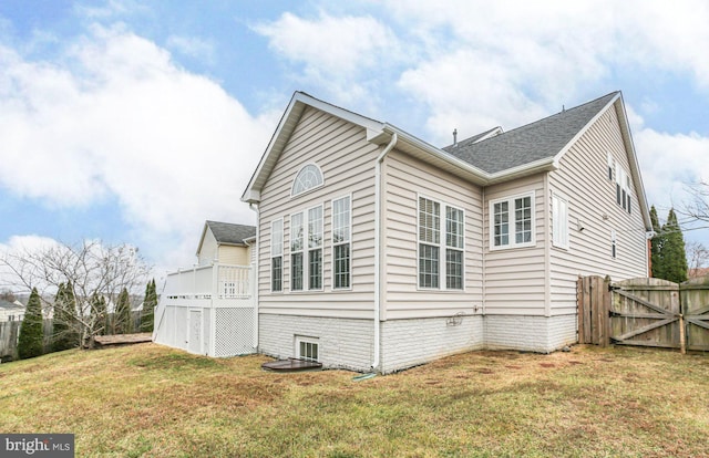 view of property exterior with a yard and a deck