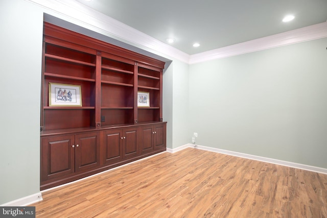 unfurnished room featuring ornamental molding and light wood-type flooring