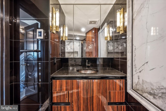 bathroom with visible vents, vanity, and decorative backsplash