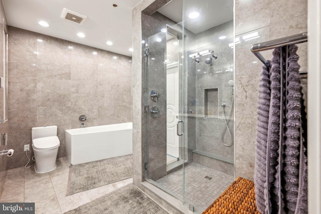 bathroom featuring tile patterned flooring, an enclosed shower, tile walls, and toilet