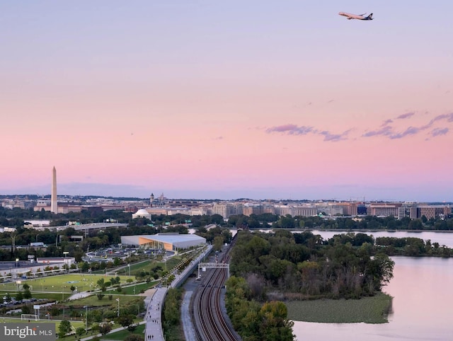 aerial view at dusk featuring a water view