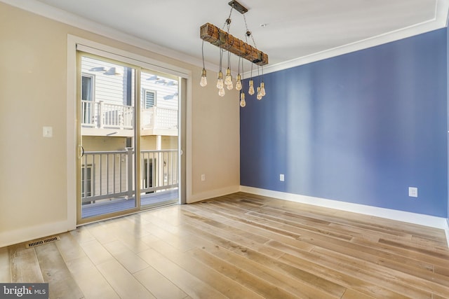 unfurnished room with an inviting chandelier, crown molding, and light hardwood / wood-style flooring