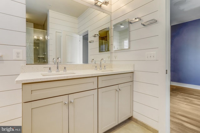 bathroom featuring walk in shower, wooden walls, vanity, and hardwood / wood-style flooring