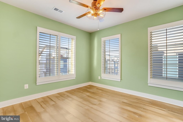 unfurnished room with ceiling fan, plenty of natural light, and hardwood / wood-style flooring