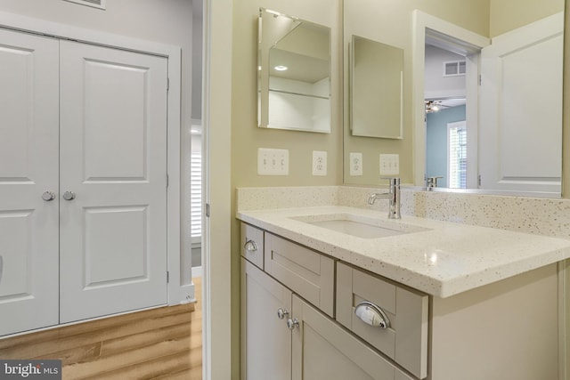 bathroom with vanity, hardwood / wood-style flooring, and ceiling fan