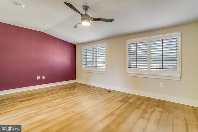 spare room featuring ceiling fan, hardwood / wood-style floors, and vaulted ceiling