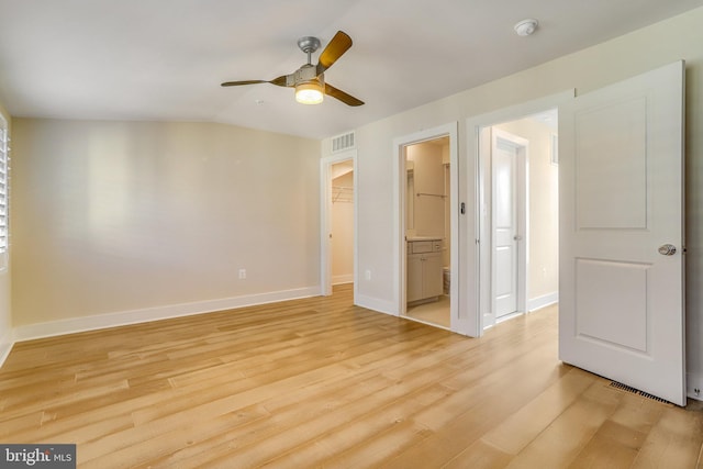 empty room featuring ceiling fan, vaulted ceiling, and light hardwood / wood-style flooring