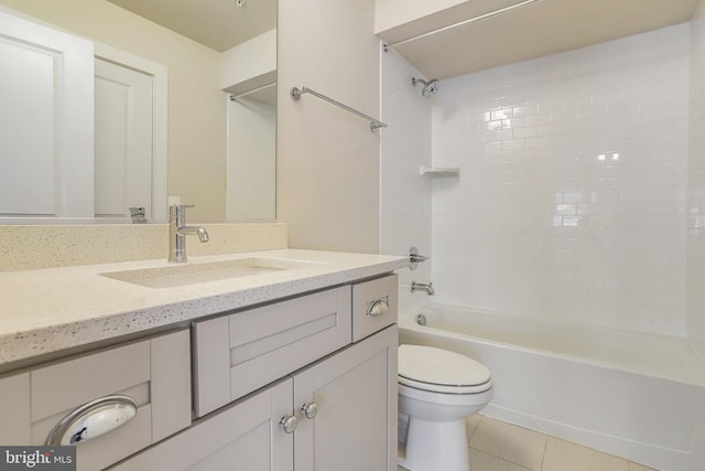 full bathroom featuring toilet, vanity, tile patterned floors, and tiled shower / bath