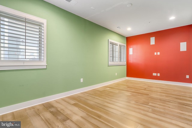 unfurnished room featuring a wealth of natural light and light hardwood / wood-style floors