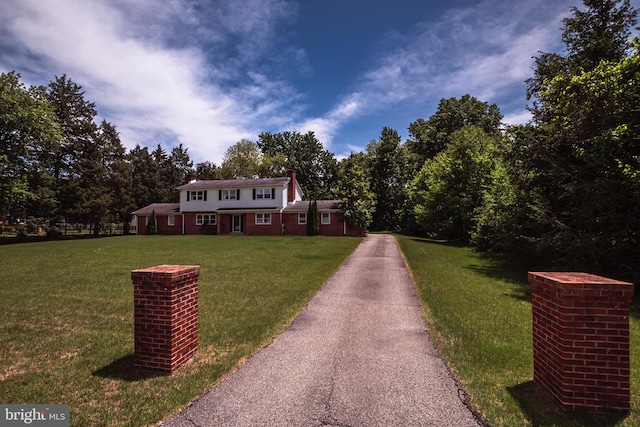 325 Great Oak Dr, Middletown, DE 19709 - colonial inspired home featuring a chimney, a front lawn, and driveway