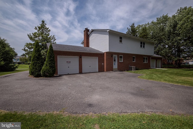 325 Great Oak Dr, Middletown, DE 19709 - view of side of property with a garage, brick siding, driveway, a chimney, and a yard