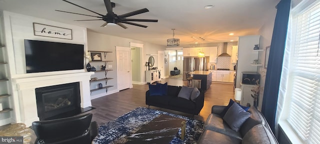 living room featuring ceiling fan and dark wood-type flooring