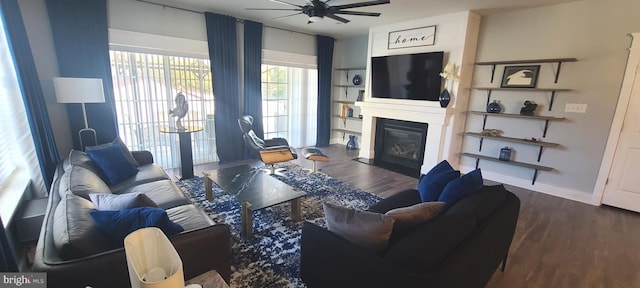 living room with a large fireplace, dark hardwood / wood-style floors, and ceiling fan