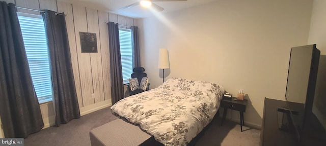 bedroom with multiple windows, ceiling fan, and dark colored carpet