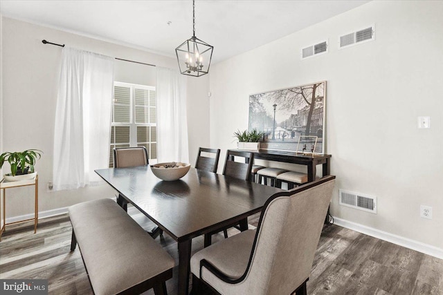 dining room featuring dark wood-type flooring and an inviting chandelier