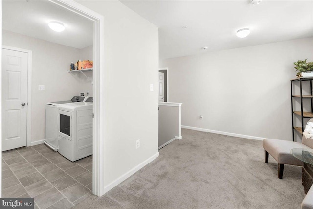 laundry room featuring light carpet and separate washer and dryer