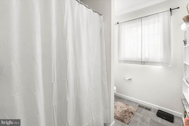 bathroom with toilet and tile patterned flooring